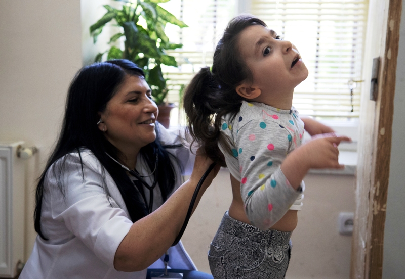 Eine Ärztin hört einem Mädchen den Rücken ab - Kinderpatenschaften können lebenswichtig sein