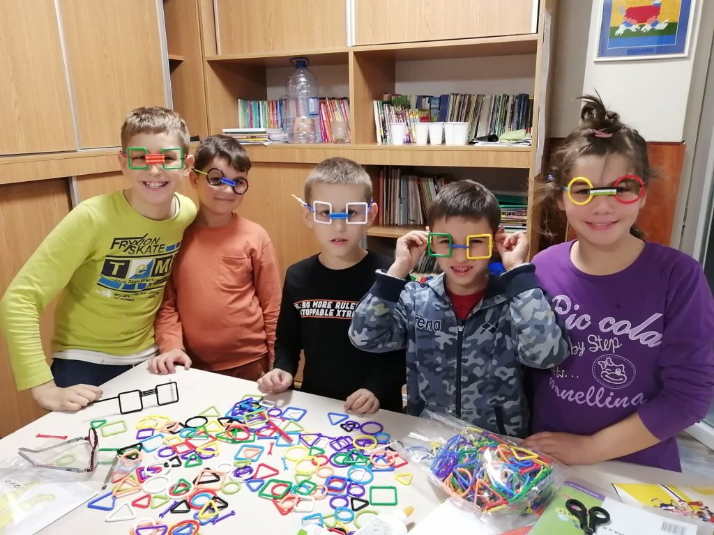 Auch Spiel und Spaß helfen bei der Trauma-Bewältigung - Fünf Kinder probieren selbst gebastelte Brillen aus Plastikteilen an