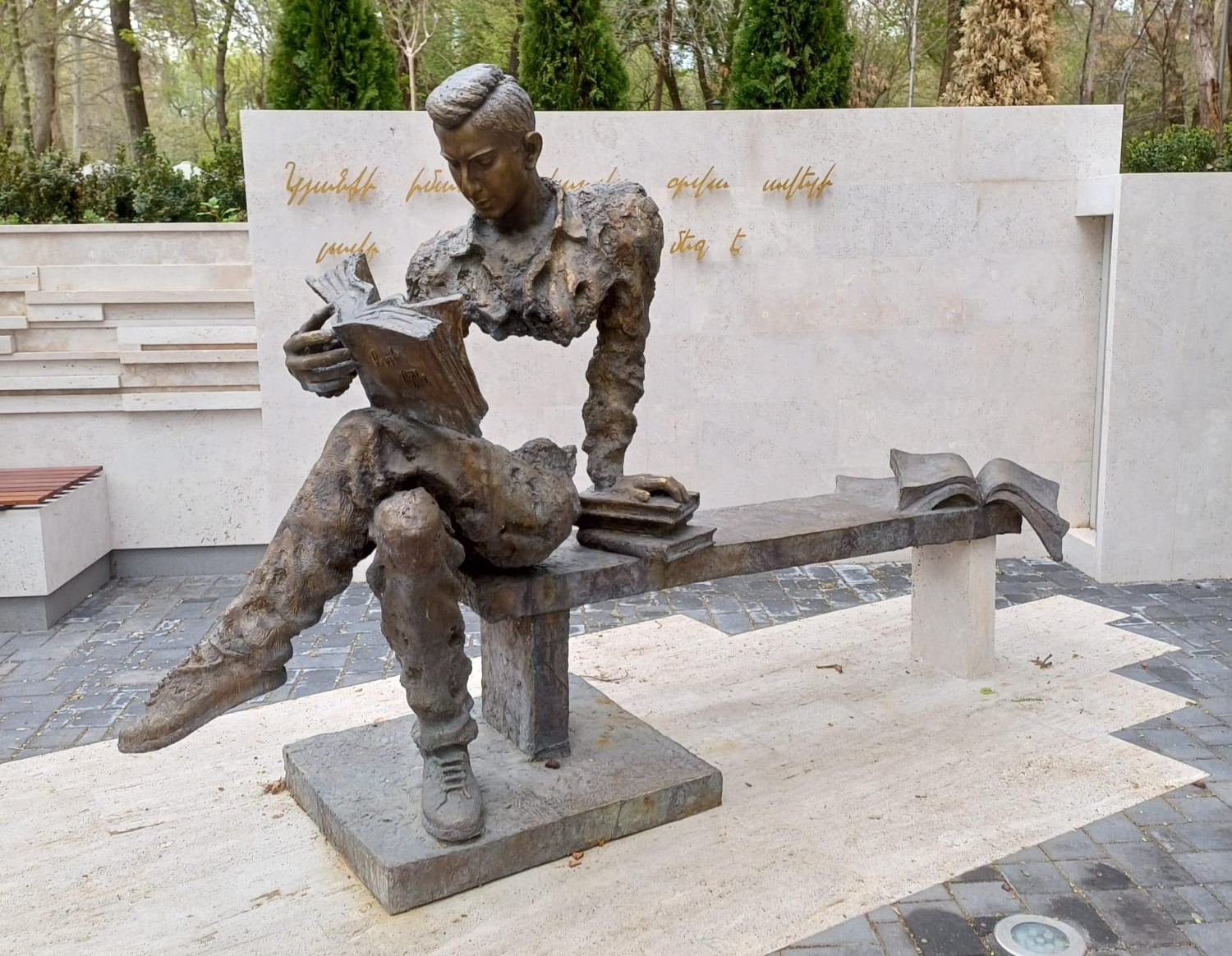 Skulptur eines jungen Mannes, der ein Buch liest