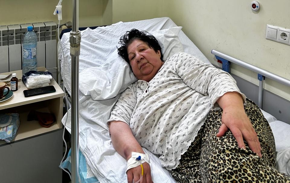 Eine ältere Frau liegt in einem Krankenhausbett. 