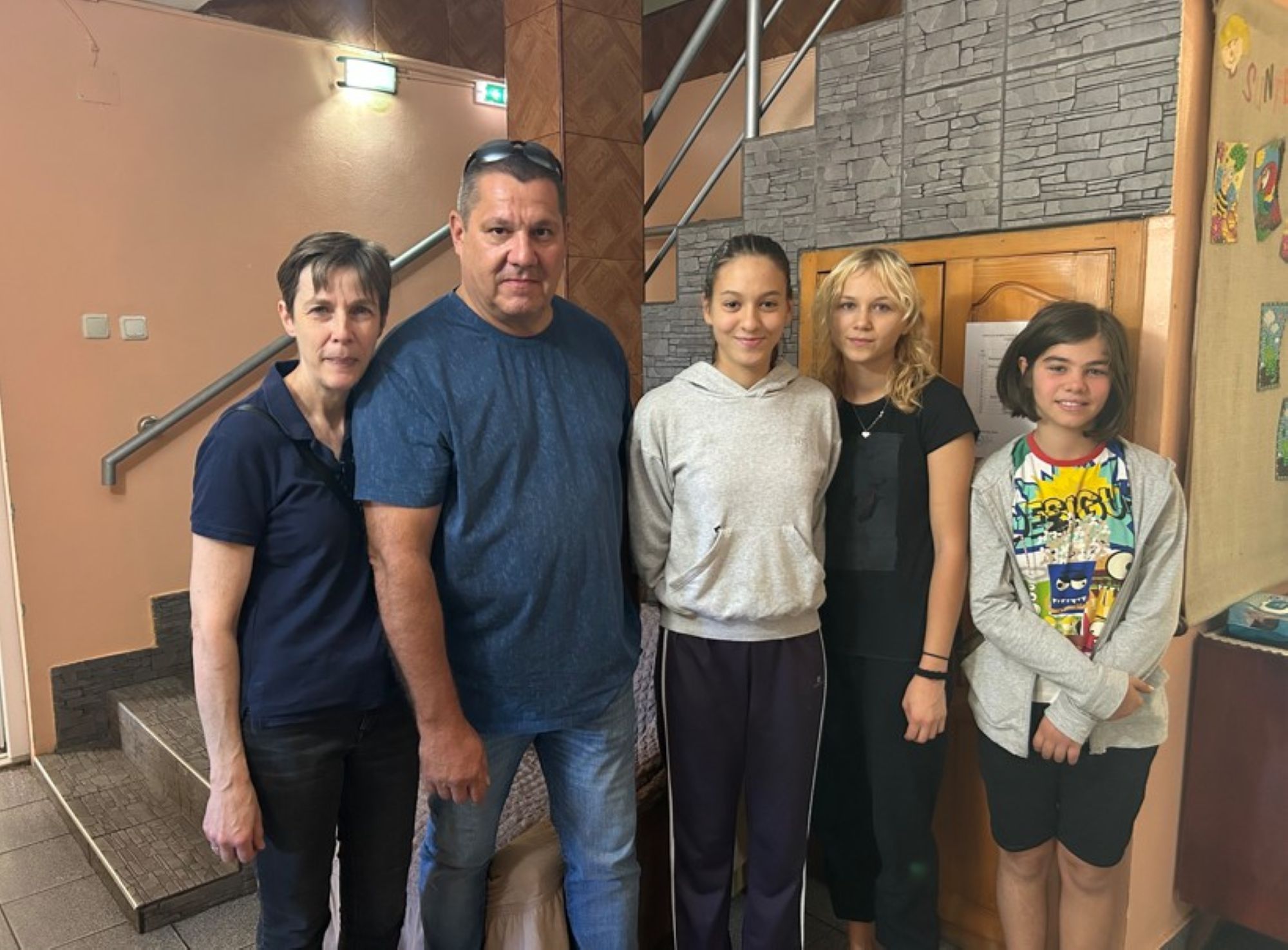 Ein Mann und eine Frau stehen neben drei jungen Mädchen.