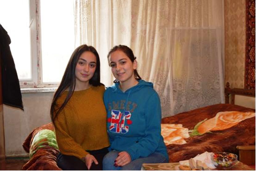 Zwei junge Frauen sitzen auf einem Bett