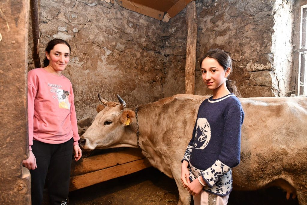 Eine Frau und ein Mädchen stehen neben einer Kuh