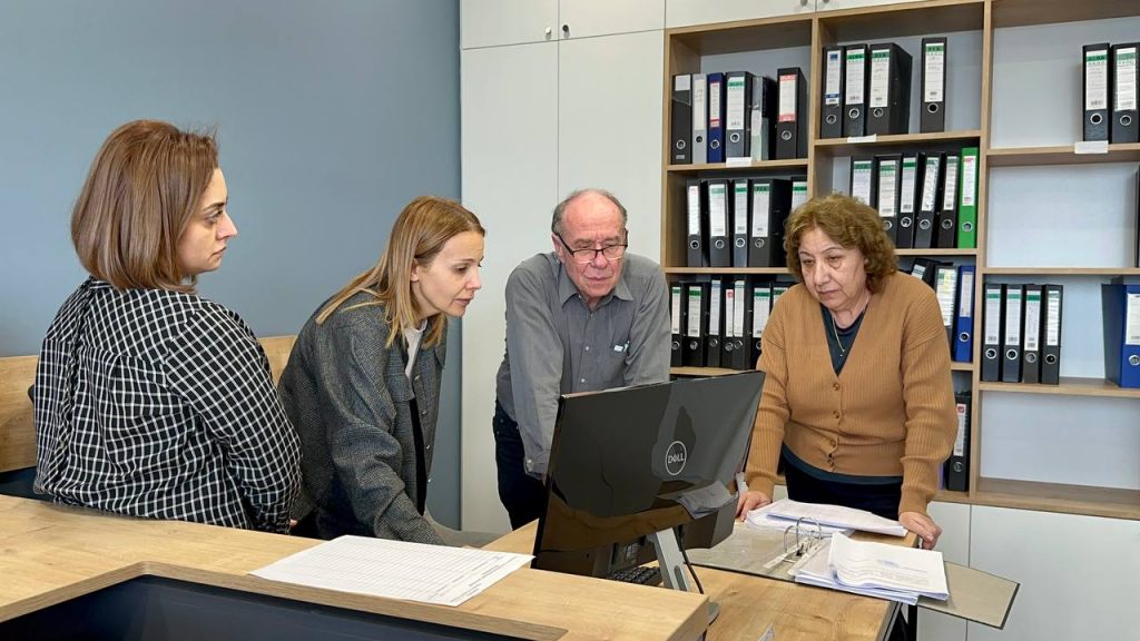 Michael Schmidt und drei Mitarbeiterinnen des DCF schauen auf einen Computer